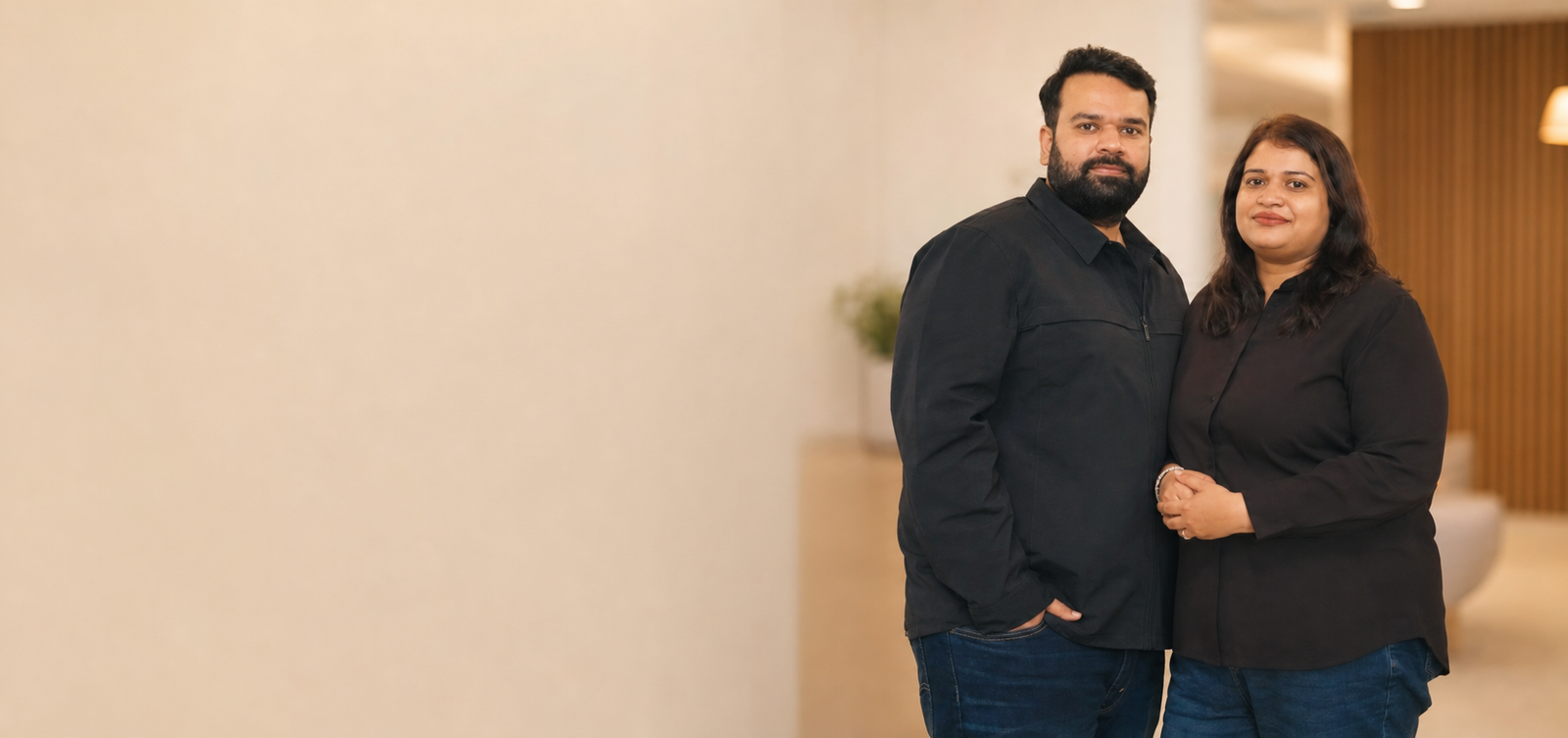 Dr. Swati Verma and Vaibhav Sharma, co-founders of Glamveda, in matching black outfits inside a warm-lit office